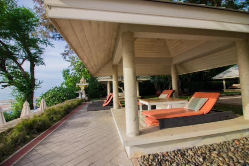 a porch with orange chairs and a table at Baan Bayan - Hua Hin - SHA Extra Plus in Hua Hin