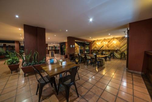 a restaurant with tables and chairs in a room at Bukoto Heights Apartments in Kampala