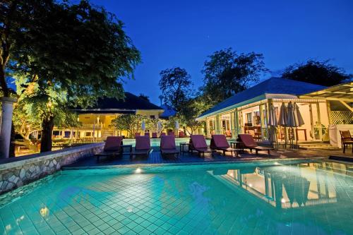 a swimming pool with chairs and a house at Baan Bayan - Hua Hin - SHA Extra Plus in Hua Hin