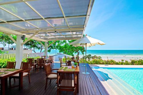 a restaurant with tables and chairs next to a swimming pool at Baan Bayan - Hua Hin - SHA Extra Plus in Hua Hin