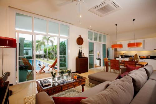 a living room with a couch and a table at Two Villas HOLIDAY - Oxygen Style Bangtao Beach, Phuket in Bang Tao Beach