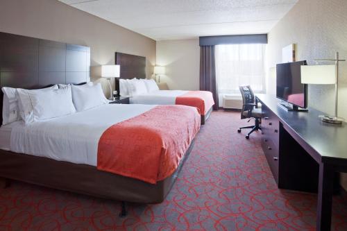 a hotel room with two beds and a desk at Holiday Inn Express & Suites Bloomington West by IHG in Bloomington