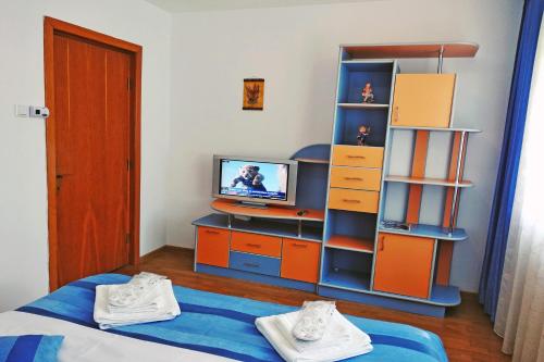 ピアトラ・ネアムツにあるLaguna Apartmentのベッド1台、テレビ、デスクが備わる客室です。