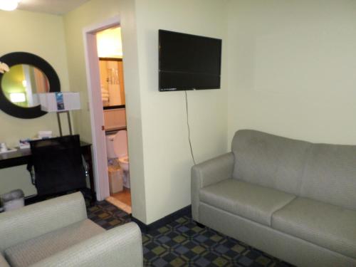 a living room with a couch and a flat screen tv at Travelodge by Wyndham Cleveland Lakewood in Lakewood