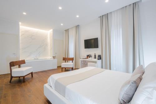 a bedroom with a white bed and a desk and chair at Palazzo Cini Luxury Rooms in Pisa in Pisa