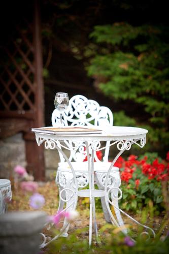 a white table in front of a garden with flowers at Friars Quarter House in Ballinrobe