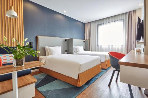 南京的住宿－南京玄武湖智选假日酒店，酒店客房配有两张床和一张书桌