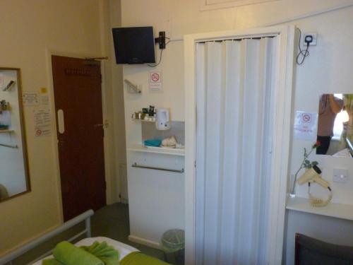 a small room with a white refrigerator and a television at The Berkswell in Blackpool