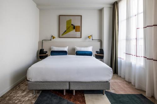 A bed or beds in a room at Le Grand Quartier