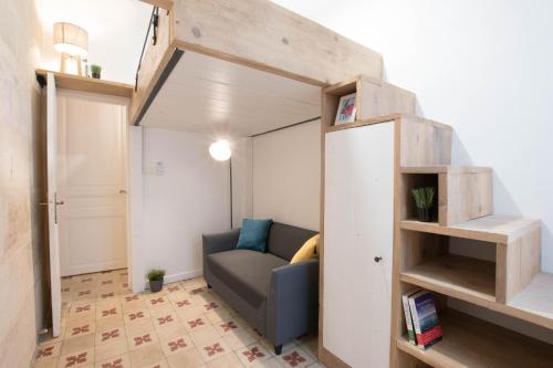 un salon avec un canapé et une étagère dans l'établissement Duplex Liberté-Grande Terrasse-Clim-Quartier Roquette, à Arles