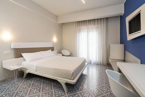 a hotel room with two beds and a television at Saracen Sands Hotel & Congress Centre - Palermo in Isola delle Femmine