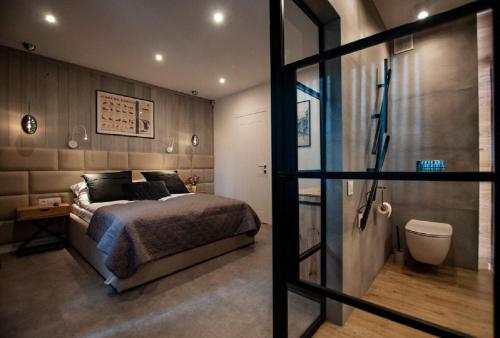 a bedroom with a bed and a bathroom with a shower at Apart-Center Przy Krupówkach in Zakopane