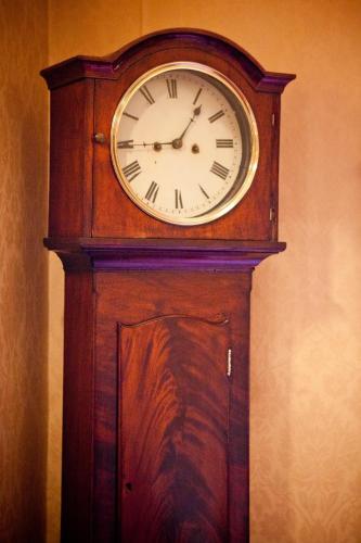 a wooden grandfather clock sitting against a wall at Friars Quarter House in Ballinrobe