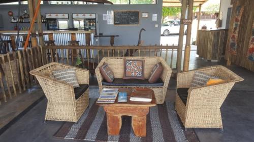 two wicker chairs and a coffee table on a porch at Mwandi View in Kavimba