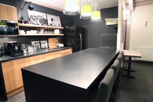 a kitchen with a black counter top in a room at Aux 5 Sens in Tillé