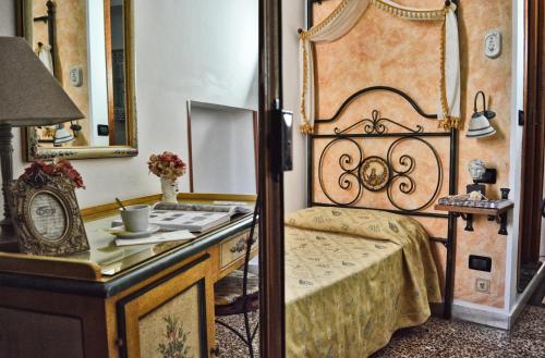 Hotel Victoria في تاورمينا: غرفة نوم مع سرير وغطاء مع مرآة