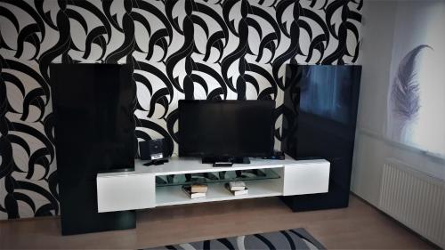 ein Wohnzimmer mit einem TV und einer schwarz-weißen Wand in der Unterkunft Ferienwohnung Gossel in Bad Wildungen