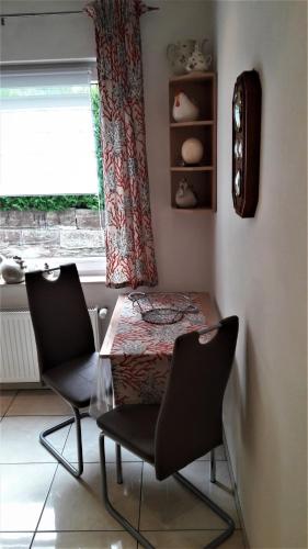 einen Tisch und zwei Stühle in einem Zimmer mit Fenster in der Unterkunft Ferienwohnung Gossel in Bad Wildungen