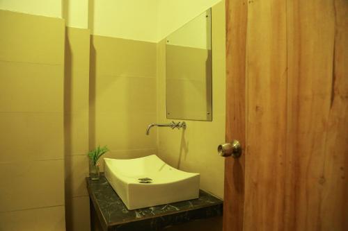 bagno con lavandino bianco e specchio di Hotel Sapid Luck Yala Safari a Tissamaharama