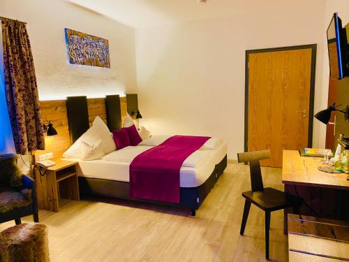 a hotel room with a bed and a desk at Sascha's Kachelofen in Oberstdorf