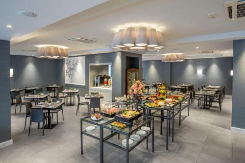 a restaurant with tables and chairs with food on them at Hotel American Palace Eur in Rome