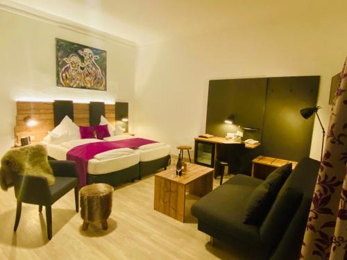 ein Hotelzimmer mit einem Bett und einem Wohnzimmer in der Unterkunft Sascha's Kachelofen in Oberstdorf