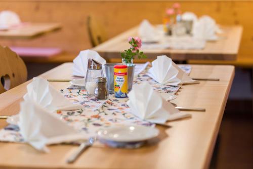 a wooden table with napkins and condiments on it at Gasthof Bauerngirgl in Bayerisch Gmain