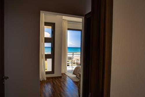 an open door to a room with a view of the ocean at Atlantis Gardens in Mazotos