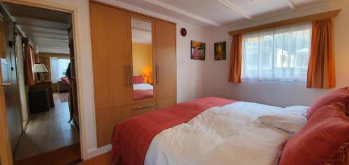 1 dormitorio con cama y ventana en Knus chalet midden in de natuur en de rust., en Wageningen