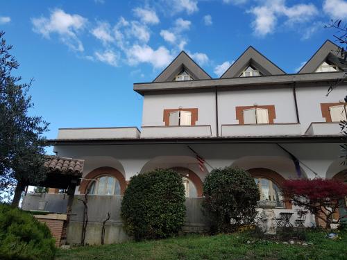 uma grande casa branca com janelas e arbustos em Hotel Rio Rè em San Marino
