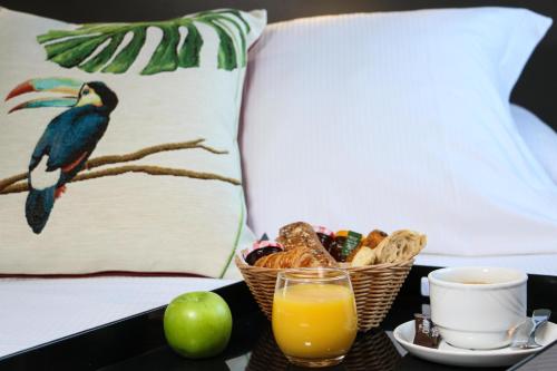 a breakfast tray with a bird and a cup of orange juice at Best Western Plus Hôtel & Spa de Chassieu in Chassieu
