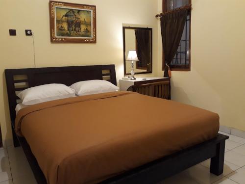 a bed in a room with a mirror and a bed sidx sidx sidx at Ma Maison Guest House in Yogyakarta