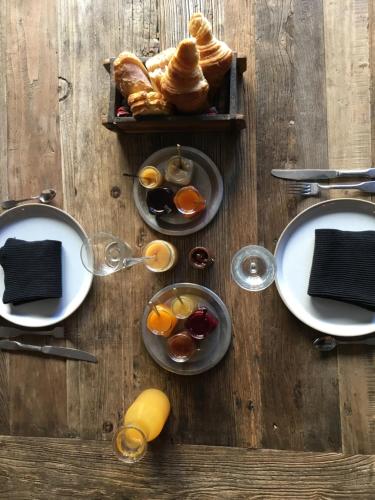 a wooden table with plates of breakfast food on it at Les Chambres de l'Imprimerie in Beaune