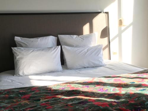 a bed with white pillows and a blanket on it at Les Chambres de l'Imprimerie in Beaune