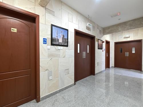 un pasillo con 2 puertas y TV en la pared en Platinium Hotel Apartments, en Seeb