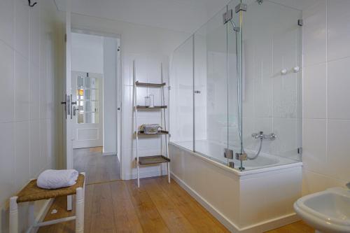 a bathroom with a shower and a tub and a sink at Casa das Hortênsias - Charming Guest House in Sintra