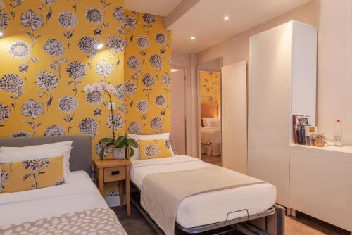 - une chambre avec 2 lits et un mur jaune dans l'établissement Hotel 29 Lepic, à Paris