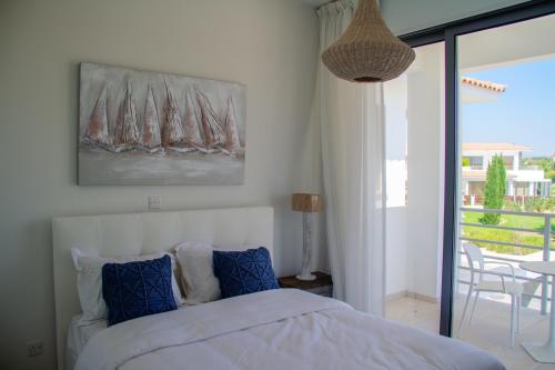 a bedroom with a bed and a view of a balcony at Atlantis Gardens in Mazotos