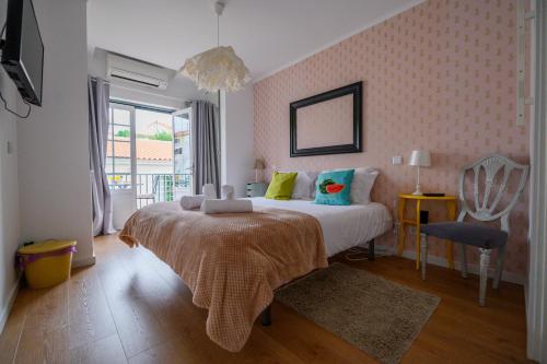 a bedroom with a bed and a chair in it at Casa das Hortênsias - Charming Guest House in Sintra