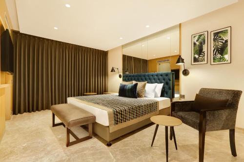 Habitación de hotel con cama y silla en Lemon Tree Hotel Viman Nagar Pune, en Pune