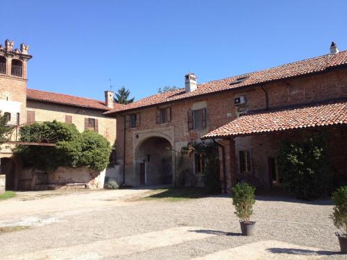 een groot bakstenen gebouw met een boog op een binnenplaats bij Ostello Artemista Ass. Ostelli Lombardia in Spessa