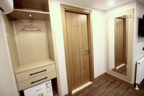 a closet with a wooden door and a mirror at Hira Hotel in Istanbul