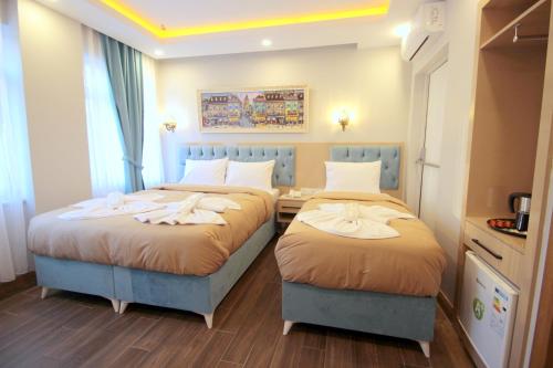 two beds in a hotel room withskirts at Hira Hotel in Istanbul