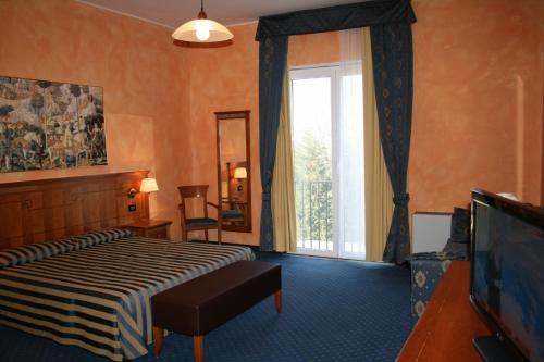 ein Hotelzimmer mit einem Bett und einem Fenster in der Unterkunft Hotel De La Ville in Bereguardo