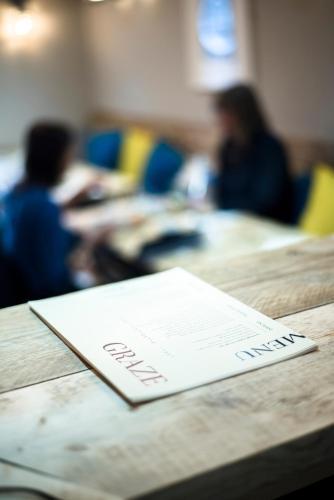 a table with a paper on it with people in a room at The Lodge Duxford in Duxford