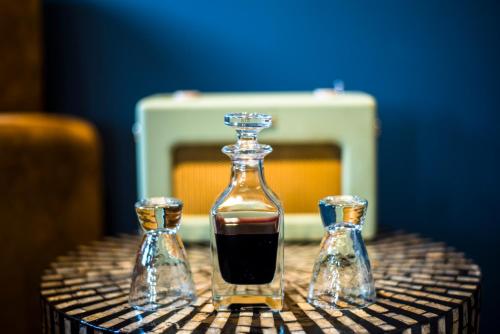 a decanter with two small bottles on a table at The Lodge Duxford in Duxford