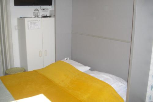 a bedroom with a bed with a yellow blanket at L'olivade Lou mas li pitchoun in Gordes