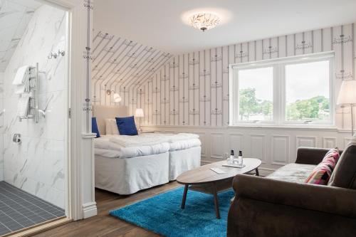 ein Schlafzimmer mit einem Bett, einem Sofa und einem Tisch in der Unterkunft Höörs Gästgifwaregård in Höör