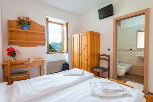 アーヴィオにあるRifugio Monte Baldoのベッドルーム1室(ベッド1台付)、バスルーム(バスタブ付)が備わります。
