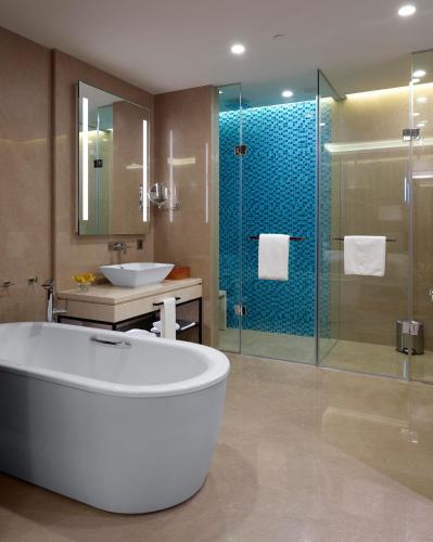 a bathroom with a tub and a sink and a shower at Hyatt Regency Thrissur in Trichūr